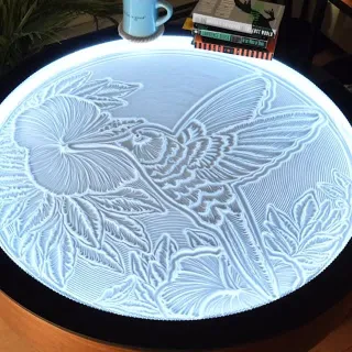 The Oasis Coffee Table sculpts a delicate hummingbird, bringing nature’s grace to your living space.